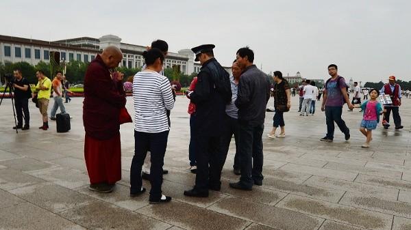 2013年6月22日,中共警察在北京天安门广场对藏族游客进行身份核查。(图片来源:MARK RALSTONAFP via Getty Images)